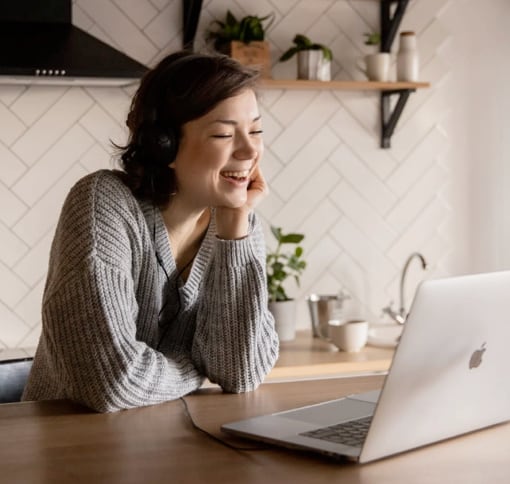 Woman sitting with headset on in front of lap top video chating