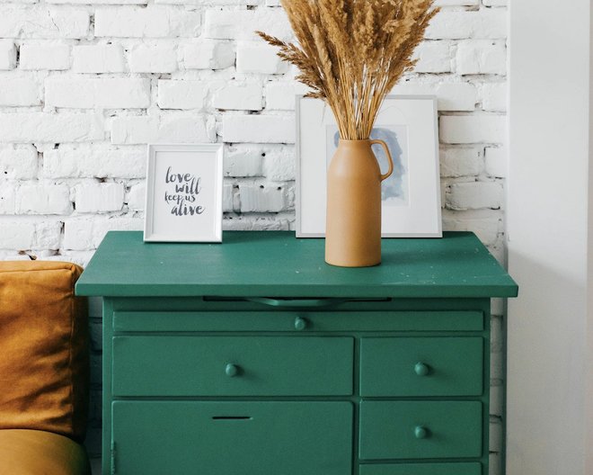 Green drawer table with vase on top