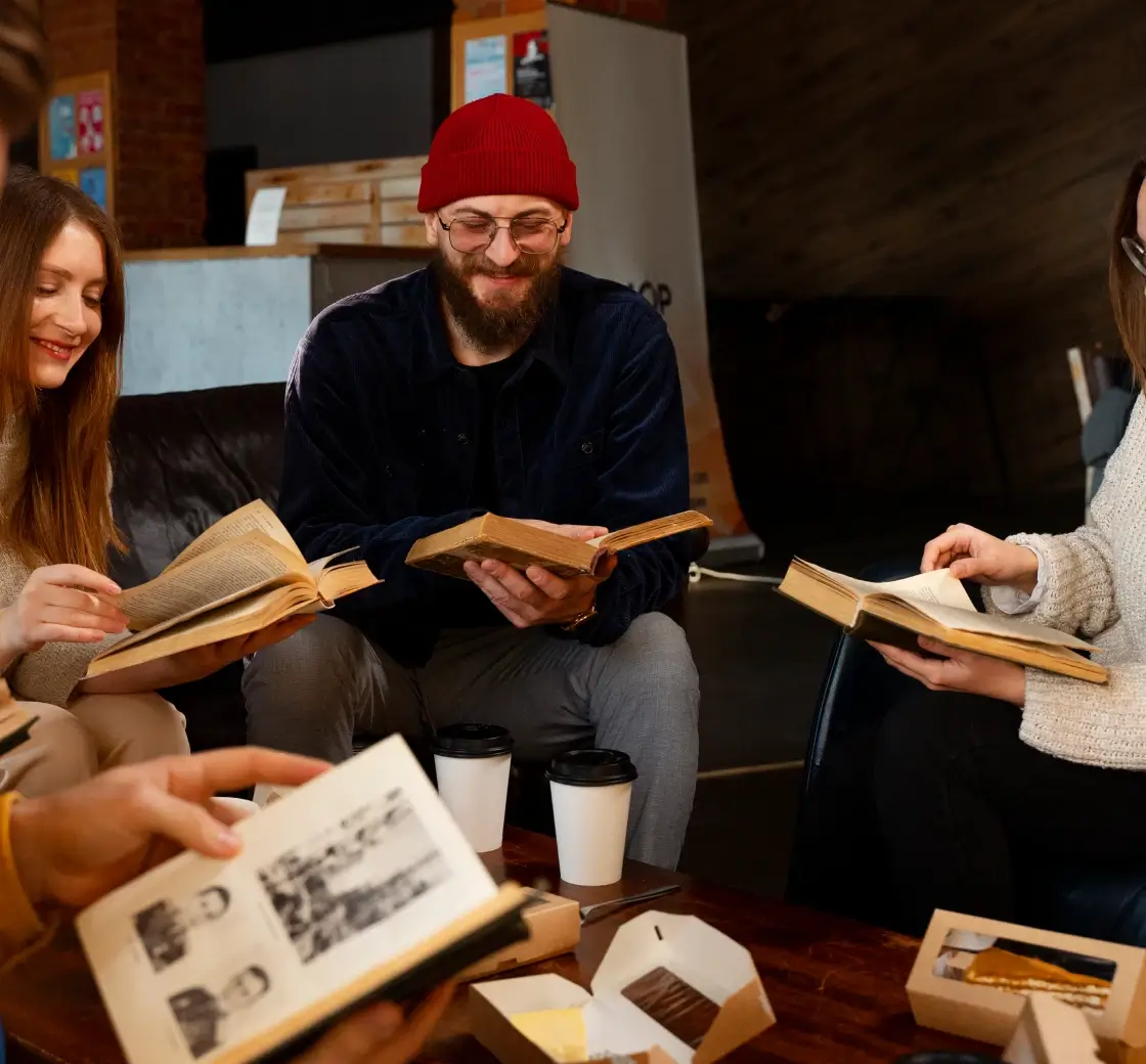 Group of four people reading books together